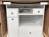 une armoire blanche avec des tiroirs et un micro-ondes sur roulettes