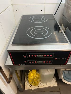 a black stove top in the corner of a kitchen