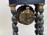 a clock that is sitting on a stand on a table