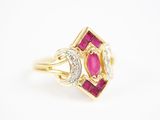 un gros plan d'une bague en or sertie d'un rubis et d'un diamant