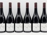 six bottles of red wine are lined up in a row