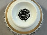 a white bowl with a black and gold design on it