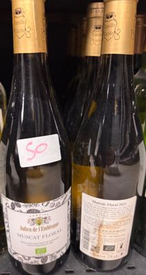 deux bouteilles de vin posées sur une étagère dans un magasin