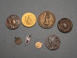 quelques pièces et un pin's sont posés sur une table
