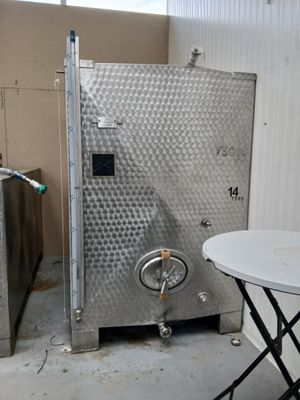 une image représentant une pièce avec une table et un grand réservoir métallique