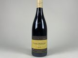 une bouteille de vin posée sur une table blanche