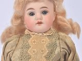 a small doll with blonde hair and a dress on