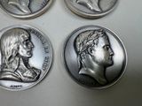 four different types of silver coins are shown on a white surface