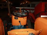 an orange tractor with a bucket on the back of it