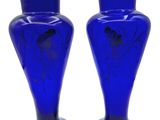 two blue vases sitting next to each other on a white surface