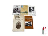 several books sitting on top of each other on a white surface