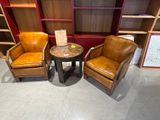 two chairs and a table in a room with bookshelves