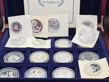 un assortiment de pièces d'argent présenté dans un coffret, accompagné de cartes et d'enveloppes