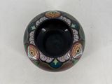 a small black bowl with a floral design on it