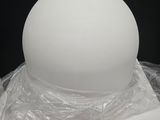 a large white ball sitting on top of a plastic bag