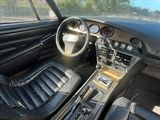 une photo du tableau de bord d'une voiture avec des sièges en cuir et les commandes du tableau de bord
