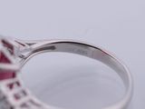 a close up of a ring with a red stone in it