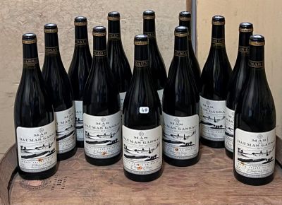 bottles of wine are lined up on a barrel on a table