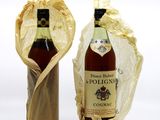two bottles of wine sitting next to each other on a white surface