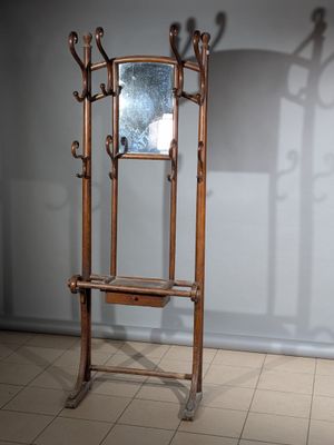 un miroir et un porte-manteau dans un coin de la pièce