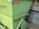 a green dumpster sitting on the side of the street