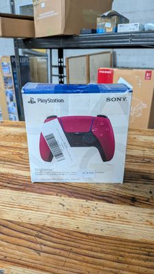 une boîte sur laquelle est posé une manette de jeu, posée sur une table