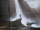 une image d'une affiche du film « Oblivion » représentant un homme debout au sommet d'une montagne