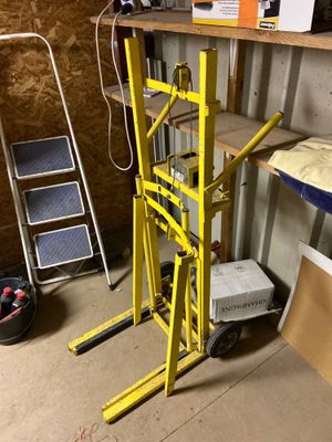 un chariot élévateur jaune dans un garage, à côté d'une étagère