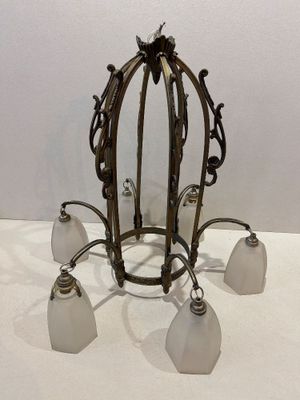 un lustre auquel sont suspendus cinq abat-jours en verre