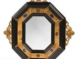 un miroir ouvragé doté d'un cadre noir et de finitions dorées