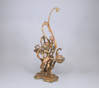 sculpture en bronze représentant une femme assise sur une branche ornée de fleurs