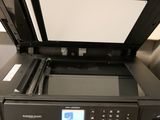 the printer is sitting on top of the desk with the paper in it