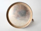 a silver plate with a handle on a white surface