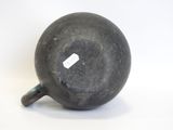 a black vase sitting on a white surface with a tag on it