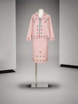 une photo d'une robe et d'une veste roses sur un présentoir à mannequin