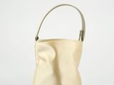beige leather bucket bag with handle on white background
