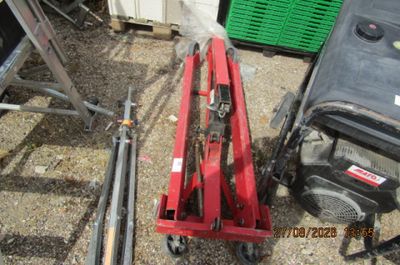 une photo d'une machine rouge posée au sommet d'un tas de ferraille
