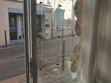 un ours en peluche assis dans la vitrine d'un magasin