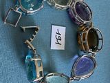 un bracelet en verre et en métal, orné d'une plaque