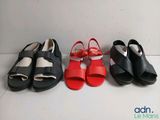 three pairs of black, red and white sandals are lined up on a white surface