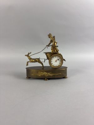 une horloge en or sur laquelle figurent une dame et un chien