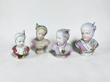 quatre figurines en porcelaine représentant des femmes coiffées de chapeaux et vêtues de robes, sur fond blanc