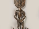 une sculpture en bois représentant un homme tenant un poisson