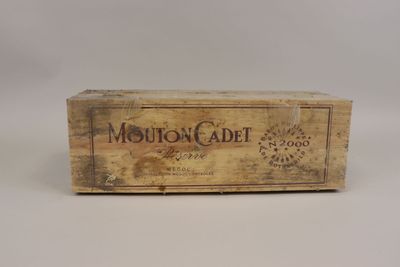 une vieille boîte en bois sur laquelle est collée une étiquette portant l'inscription « Mouton Cadet »