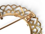 a gold brooch with a diamond in it