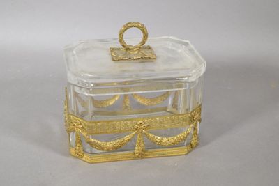 a small glass box with a gold decoration on it