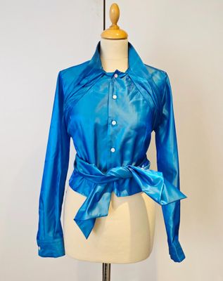 un gros plan sur le torse d'un mannequin vêtu d'une chemise bleue