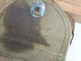 a close up of a hat with a rusted cap on it