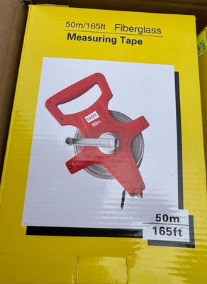 packaging of a red measuring tape in a box on a table