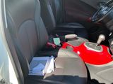 a car with a red and black seat belt and a red and black bag in the passenger seat